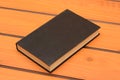 Black book mockup on wooden table, study theme Royalty Free Stock Photo