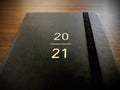 A black book of 2021 on a wooden background.