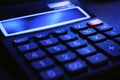 Black bookkeeping. Modern office small calculator on the table on a dark background. Macro shot with perspective Royalty Free Stock Photo