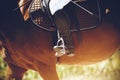 In a black boot, the foot of a rider bases on a stirrup, sitting astride a Bay horse Royalty Free Stock Photo