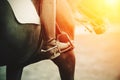 In a boot with a spur, the foot of a rider sitting astride a horse in the sunlight Royalty Free Stock Photo