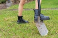 Black boots and a shovel on a green grass