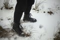 Black boots in winter. Girl in men\'s shoes. Snow shoes black clothes