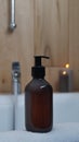 Black bottle of bubble bath and candles on tub indoors Royalty Free Stock Photo