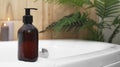 Black bottle of bubble bath and candles on tub indoors, space for text Royalty Free Stock Photo