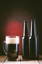 black bottle and mug beer on a dark background with red light/black bottle and mug beer on a dark background with red light. Royalty Free Stock Photo