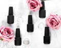 Black bottles of nail polish on a background of flowers. Manicure design. Royalty Free Stock Photo