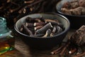 Bowl of Common comfrey or symphytum officinale roots. Bottle of infusion or tincture. Dried comfrey officinalis roots, Bistoret.