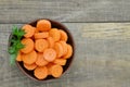 Black bowl with cut carrots fit on wooden background Royalty Free Stock Photo