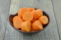 Black bowl with cut carrots thick on wooden table Royalty Free Stock Photo