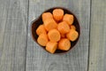 Black bowl with cut carrots thick on wooden table Royalty Free Stock Photo