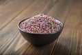 Bowl of dry healthy heather flowers on wooden table