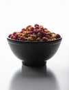 Black Bowl Filled With Colorful Round Cereal on White Background Tabletop Royalty Free Stock Photo
