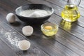 Black bowl with flour. Glass bottle with butter, eggs, eggshell Royalty Free Stock Photo