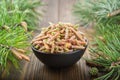 Black bowl of pine buds. Pine tree buds and twigs with needle on wooden table