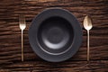 Black bowl plate fork spoon on wooden table background Royalty Free Stock Photo