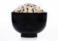 Black bowl of raw organic basmati long grain and wild rice on white background. Healthy food Royalty Free Stock Photo