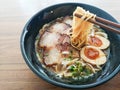 A black bowl of Shoyu Ramen noodles with pork and eggs on wooden table Royalty Free Stock Photo