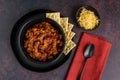 Black bowl of spicy chili con carne on a rustic moody background Royalty Free Stock Photo