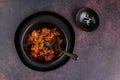 Black bowl of spicy chili con carne on a rustic moody background Royalty Free Stock Photo