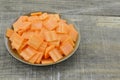 Black bowl with thin slices carrots on wooden table Royalty Free Stock Photo