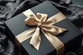 A black box adorned with a gold bow on top, sitting on a surface, Elegant black gift box with gold ribbon, AI Generated Royalty Free Stock Photo