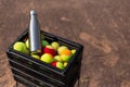 Black box with a lot of tennis balls and one steel thermo bottle for water. On tennis court. Say no to plastic bottles. Royalty Free Stock Photo