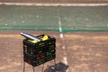 Black box with a lot of tennis balls and one steel thermo bottle for water. On tennis court. Say no to plastic bottles. Royalty Free Stock Photo