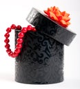 A black box tied with a orange satin ribbon bow