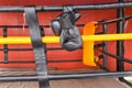 Black boxing gloves hang on hanging on ropes of ring. Royalty Free Stock Photo