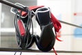 Black boxing gloves, jump rope and red hand wraps hanging on ring ropes Royalty Free Stock Photo