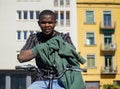 A black boy from Africa puts on a green sweatshirt on top of his bike. urban styling