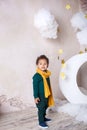 Black boy in a green sweater and a yellow scarf smiling. Portrait of a little African American. Baby smiles. A black boy stands ne Royalty Free Stock Photo