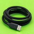 Black Braided USB Cable on a Green Background Royalty Free Stock Photo
