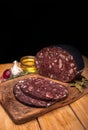 Black brawn, blood sausage, black pudding on a wood cutting board, on black background. Polish cold cuts, meat products.