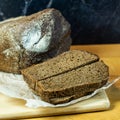 Black bread on a dark background. a loaf of bread on a wooden table. Royalty Free Stock Photo