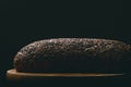 Black bread with seeds on dark background