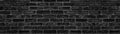 Black brick block large texture. Dark rough masonry wide screen panorama. Gloomy gothic background