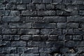 Black brick wall with a yellow fire hydrant, suitable for urban backgrounds Royalty Free Stock Photo