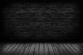 Black brick walls that are not plastered background and wooden floor. Hardwood floor texture of empty brick basement wall Royalty Free Stock Photo