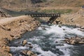 Black Bridge through the River Water Flow with Rocks in Gilgit Baltistan Highlands Royalty Free Stock Photo