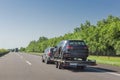 Black broken car after accident on tow truck. Car transported on car carrier trailer on highway Royalty Free Stock Photo