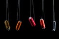 Black, bronze, orange, red and pink threads on babin soaring suspended on white thread on a black background, isolate