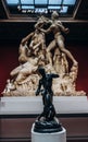 Black bronze statue on the background of the Farnese bull