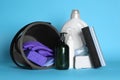 Black bucket, cleaning supplies and tools on light blue background Royalty Free Stock Photo