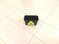 Black bucket for washing the floor with the inscription in Russian - Caution wet floor.