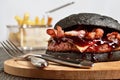 Black Burger with French fries on background