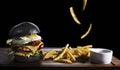Black burger and french fries isolated on black