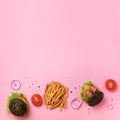 Black burger, french fries potatoes, tomatoes, cheese, onion, cucumber and lettuce on pink background. Square crop. Top view. Fast Royalty Free Stock Photo