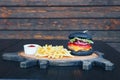 Black burger with French fries and sauce on a wooden board Royalty Free Stock Photo